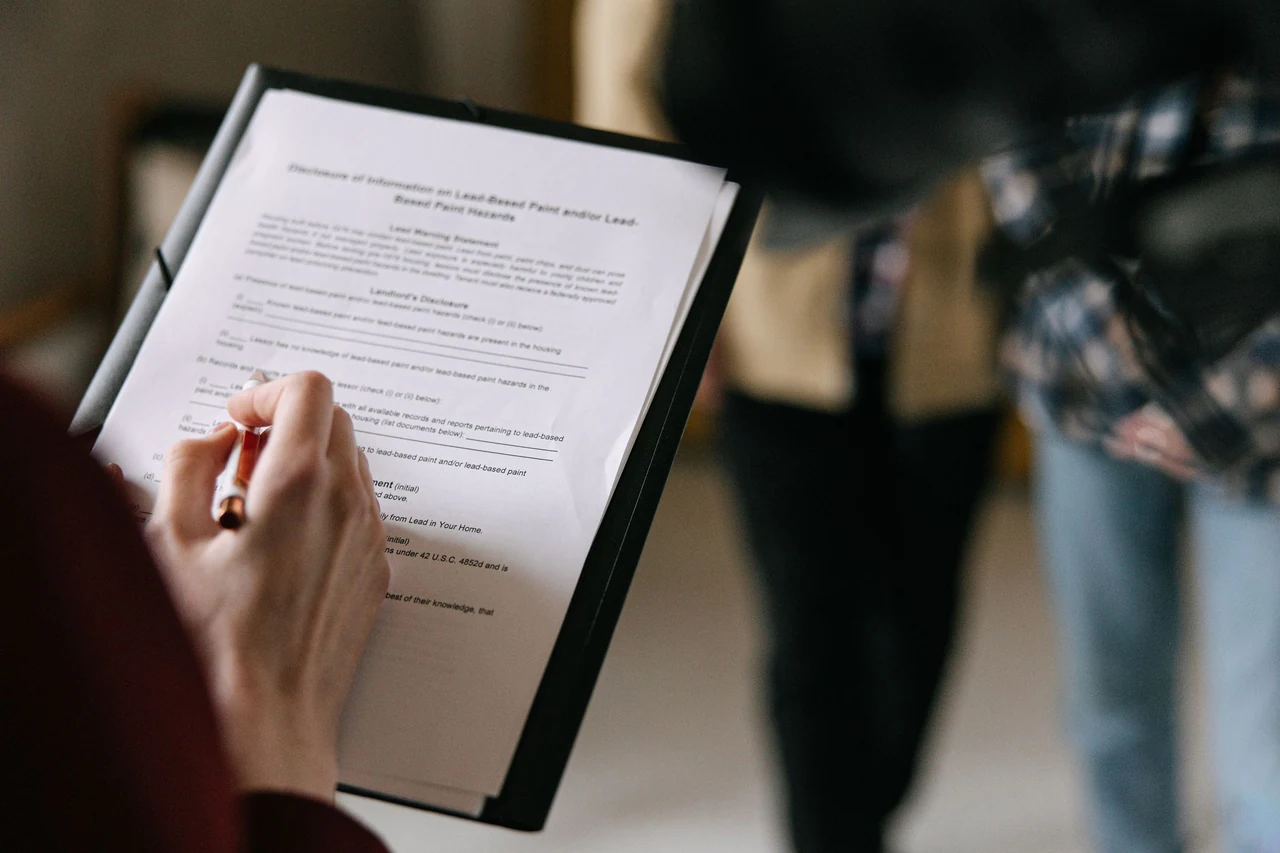 Property consultation with documents reviewed on a clipboard — stock photograph