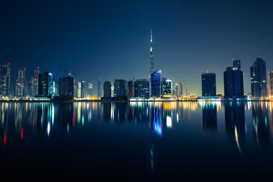Dubai’s illuminated skyline and Burj Khalifa reflected across the water